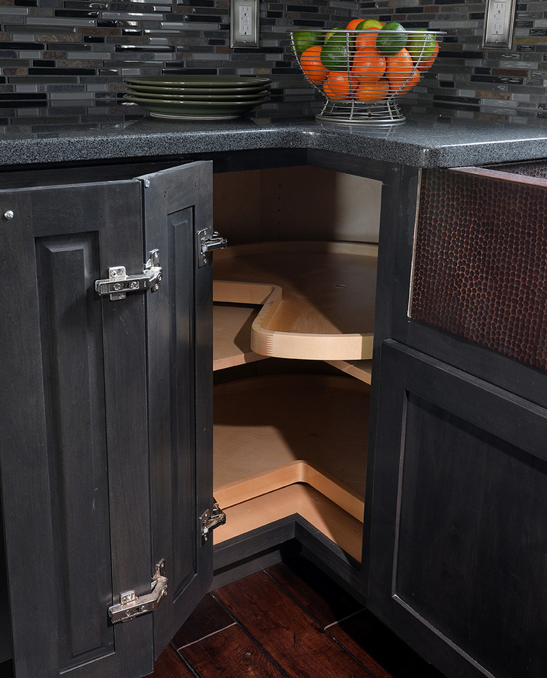 Example of a mid-sized trendy l-shaped medium tone wood floor kitchen design in Atlanta with a farmhouse sink, shaker cabinets, dark wood cabinets, granite countertops, multicolored backsplash, glass tile backsplash and an island