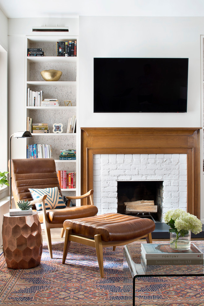 Mid-sized transitional open concept living room in New York with a library, white walls, a standard fireplace, a brick fireplace surround, a wall-mounted tv and multi-coloured floor.