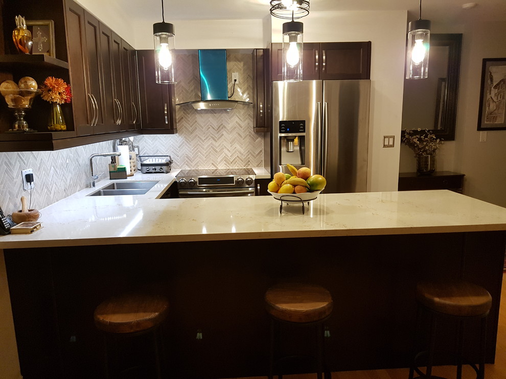 Example of a transitional u-shaped eat-in kitchen design in Toronto with an undermount sink, recessed-panel cabinets, dark wood cabinets, quartz countertops and stainless steel appliances