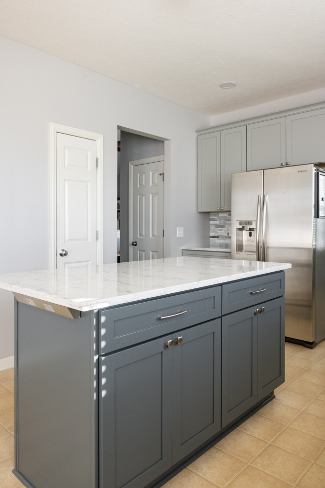 This is an example of a large traditional l-shaped eat-in kitchen in Columbus with grey cabinets, quartz benchtops, stainless steel appliances and with island.
