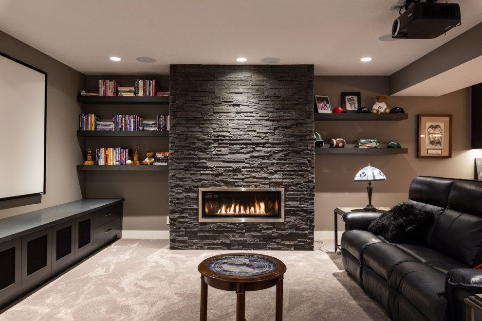 Example of a large trendy underground carpeted and beige floor basement game room design in Calgary with gray walls, a ribbon fireplace and a stacked stone fireplace
