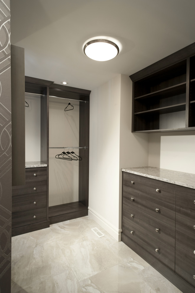 Photo of a large traditional gender-neutral walk-in wardrobe in Wilmington with flat-panel cabinets, medium wood cabinets and travertine floors.