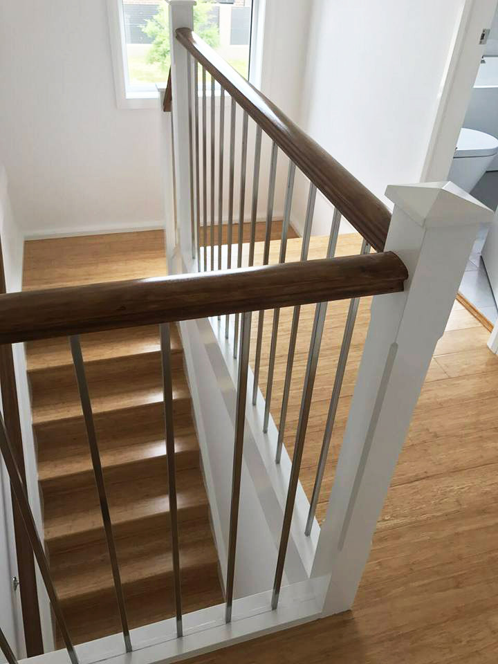Photo of a mid-sized beach style wood u-shaped staircase in Wollongong with wood risers.