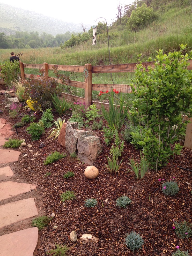 Design ideas for a large eclectic backyard full sun xeriscape in Denver with a garden path and natural stone pavers.