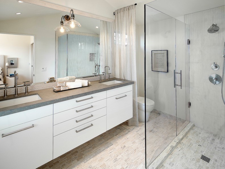 Inspiration for a mid-sized contemporary kids bathroom in Santa Barbara with flat-panel cabinets, white cabinets, white walls, limestone floors, an undermount sink, an alcove shower, a one-piece toilet, gray tile, porcelain tile and concrete benchtops.