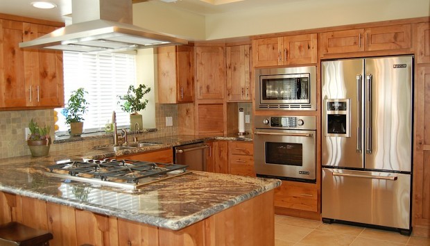 Inspiration for a mid-sized rustic u-shaped porcelain tile eat-in kitchen remodel with an undermount sink, shaker cabinets, medium tone wood cabinets, granite countertops, green backsplash, stone tile backsplash, stainless steel appliances and no island