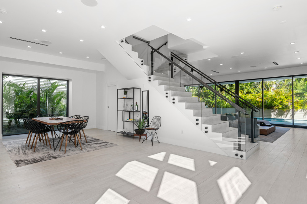 На фото: прямая лестница среднего размера в стиле модернизм с ступенями из плитки, подступенками из плитки и стеклянными перилами