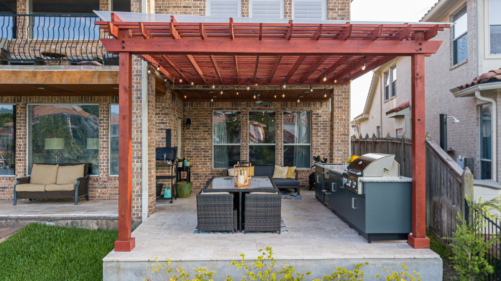 Small contemporary back patio in Houston with an outdoor kitchen, natural stone paving and a pergola.