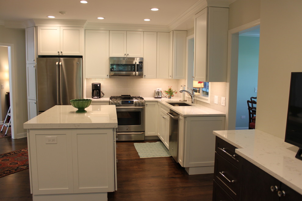 Enclosed kitchen - mid-sized transitional l-shaped dark wood floor and brown floor enclosed kitchen idea in Chicago with an undermount sink, recessed-panel cabinets, white cabinets, quartzite countertops, white backsplash, subway tile backsplash, stainless steel appliances and an island