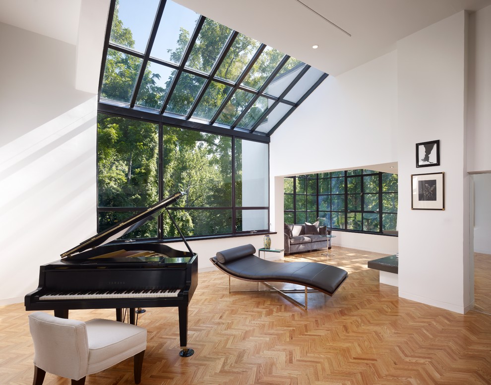 Photo of a modern living room in Philadelphia with a music area, white walls and medium hardwood floors.