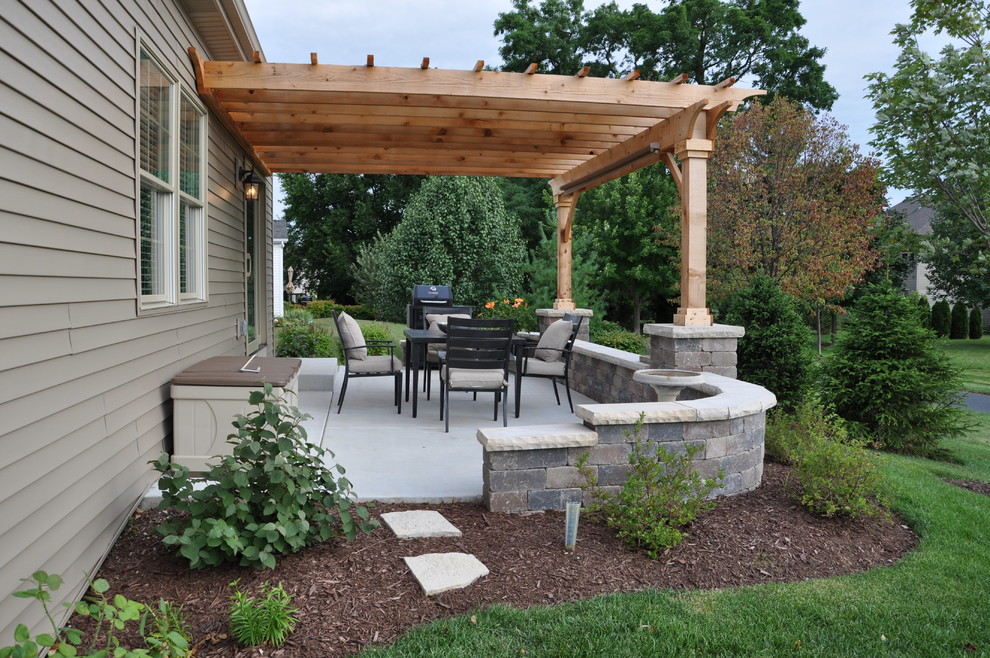 Photo of a mid-sized traditional backyard patio in Chicago with brick pavers and a pergola.