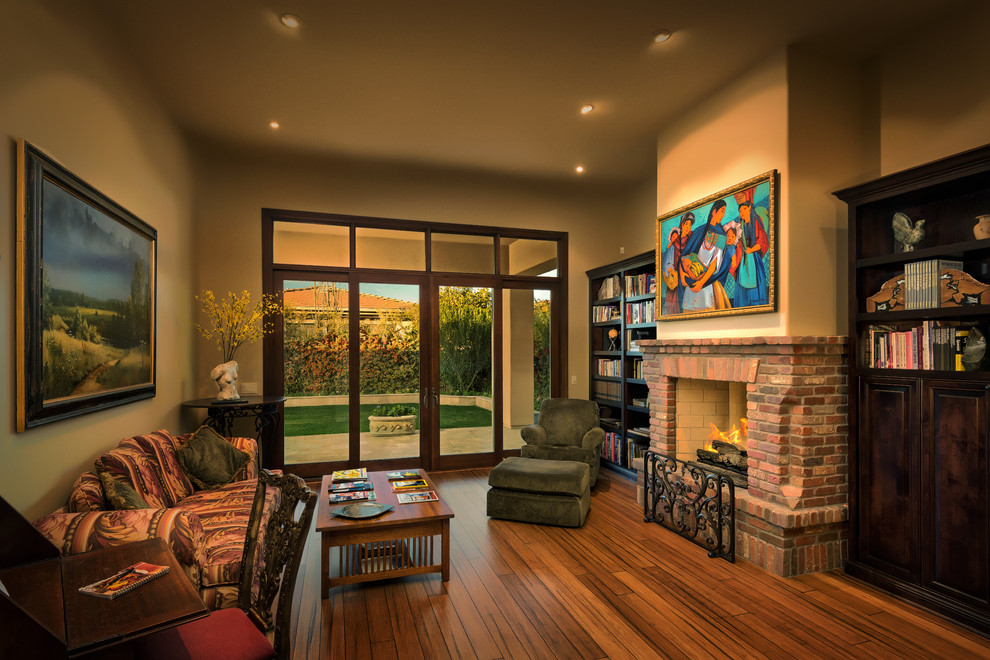 This is an example of a mid-sized traditional enclosed family room in Phoenix with beige walls, dark hardwood floors, a standard fireplace, a brick fireplace surround and no tv.