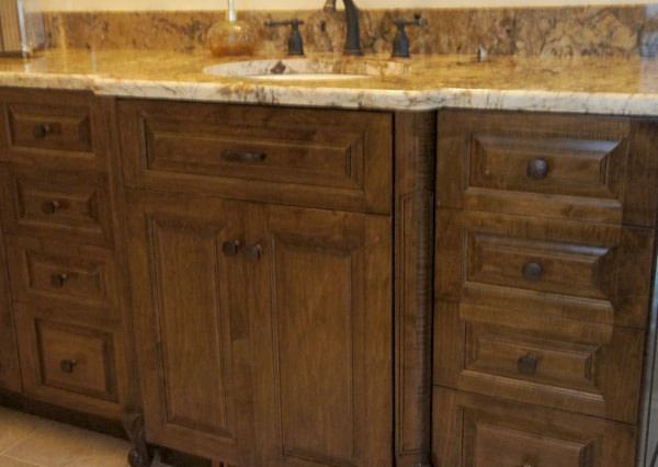Medium tone wood floor kitchen photo with raised-panel cabinets, medium tone wood cabinets, granite countertops, beige backsplash, stainless steel appliances and an island