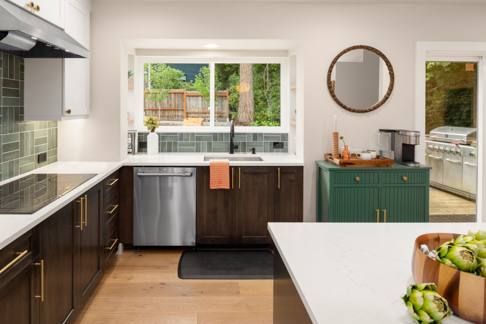 Inspiration for a medium sized traditional open plan kitchen in Seattle with a submerged sink, recessed-panel cabinets, white cabinets, engineered stone countertops, green splashback, ceramic splashback, stainless steel appliances, light hardwood flooring, an island, brown floors, white worktops and a vaulted ceiling.