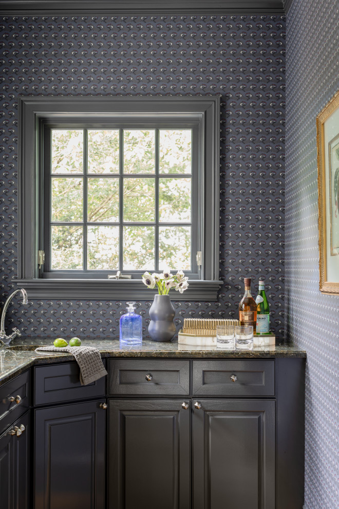 Inspiration för små klassiska l-formade grått hemmabarer med vask, med en undermonterad diskho, luckor med upphöjd panel, grå skåp, granitbänkskiva och mellanmörkt trägolv