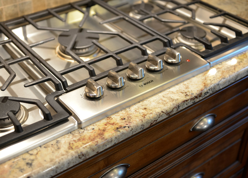 Inspiration for a large transitional u-shaped medium tone wood floor eat-in kitchen remodel with beaded inset cabinets, medium tone wood cabinets, granite countertops, beige backsplash, mosaic tile backsplash, stainless steel appliances and an island