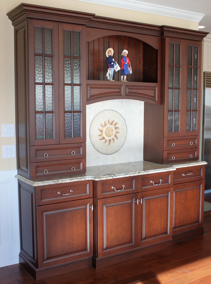 Mid-sized elegant l-shaped medium tone wood floor eat-in kitchen photo with an undermount sink, raised-panel cabinets, granite countertops, beige backsplash, ceramic backsplash, stainless steel appliances and an island