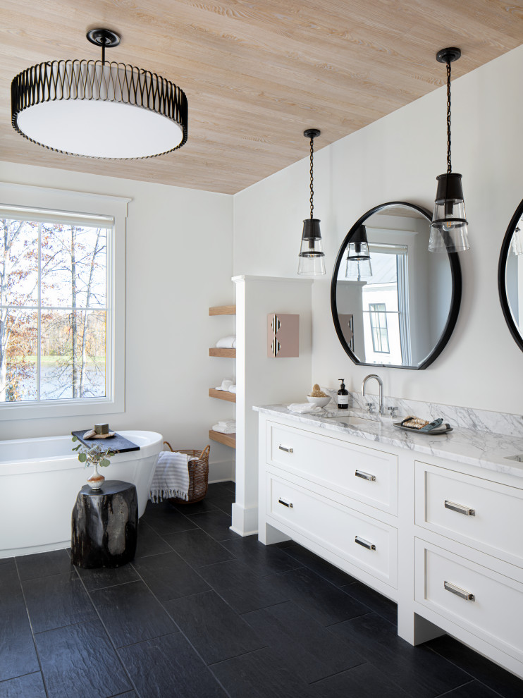 Idéer för att renovera ett litet lantligt svart svart badrum, med släta luckor, vita skåp, ett fristående badkar, svart kakel, vita väggar, klinkergolv i keramik, ett undermonterad handfat, marmorbänkskiva och svart golv