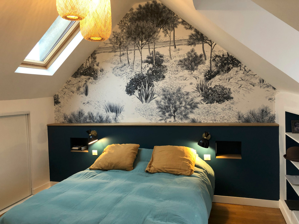 Aménagement d'une grande chambre parentale contemporaine avec un mur bleu, parquet clair, un sol marron, poutres apparentes et du papier peint.