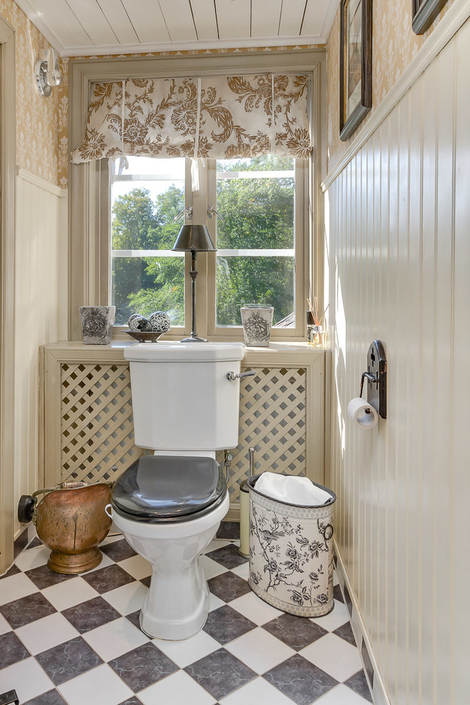 This is an example of a mid-sized country powder room in Stockholm with black and white tile and beige walls.