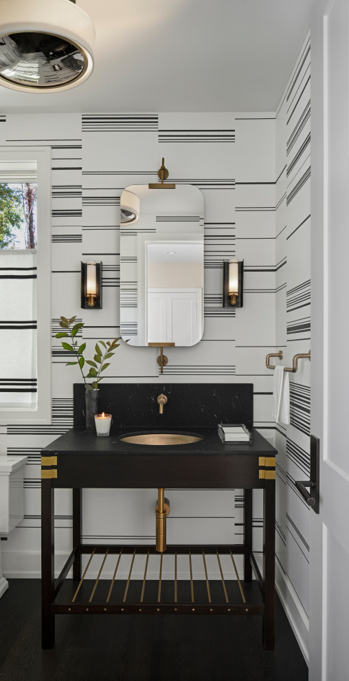 Cette image montre un WC et toilettes traditionnel avec un placard sans porte, des portes de placard noires, un mur multicolore, un lavabo encastré, un sol noir, un plan de toilette noir et meuble-lavabo sur pied.