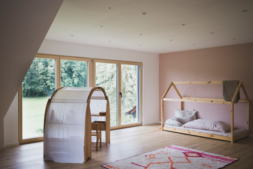 Inspiration pour une petite chambre d'enfant de 1 à 3 ans design avec un mur rose, parquet peint et un sol marron.