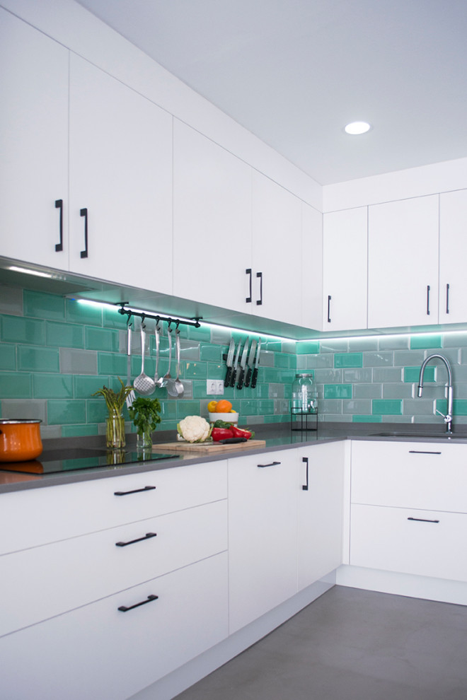 Photo of a mid-sized contemporary l-shaped open plan kitchen in Other with an undermount sink, flat-panel cabinets, white cabinets, grey floor, grey benchtop, multi-coloured splashback, subway tile splashback, porcelain floors and no island.