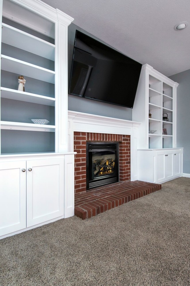 Mid-sized traditional enclosed family room in Columbus with blue walls, carpet, a standard fireplace, a brick fireplace surround, a wall-mounted tv and grey floor.