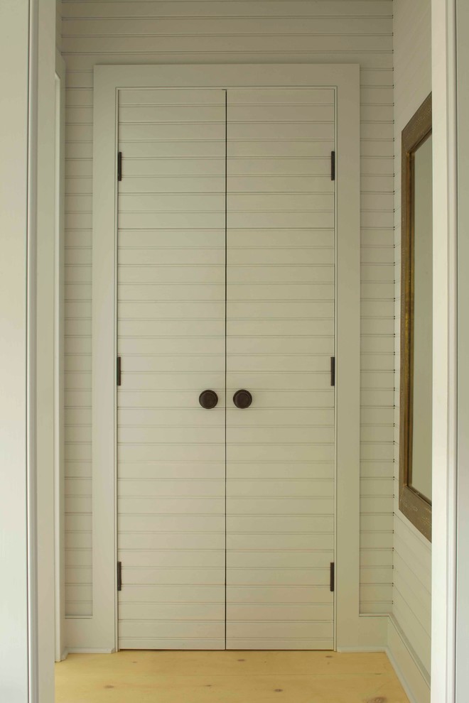 Inspiration for a country storage and wardrobe in New York with light hardwood floors.