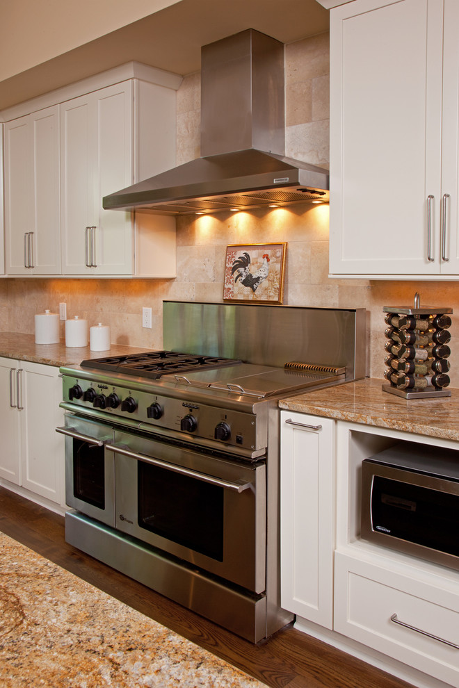 Inspiration for a large rustic l-shaped medium tone wood floor eat-in kitchen remodel in Minneapolis with an integrated sink, flat-panel cabinets, white cabinets, granite countertops, beige backsplash, ceramic backsplash, stainless steel appliances and an island