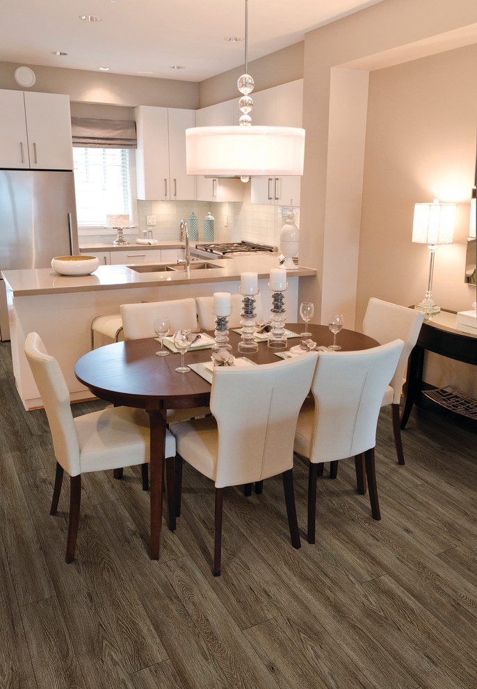 Example of a small transitional u-shaped light wood floor eat-in kitchen design with a double-bowl sink, flat-panel cabinets, white cabinets, stainless steel countertops, white backsplash, glass tile backsplash, stainless steel appliances and an island