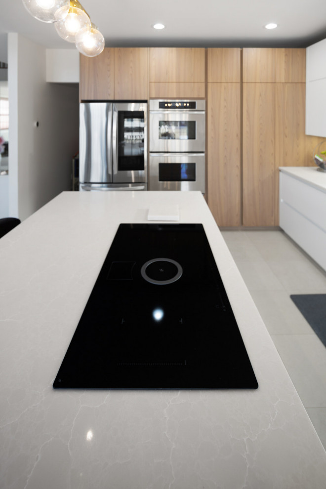 Inspiration for a mid-sized contemporary l-shaped open plan kitchen in New York with an undermount sink, flat-panel cabinets, medium wood cabinets, quartz benchtops, white splashback, engineered quartz splashback, stainless steel appliances, porcelain floors, with island, white floor and white benchtop.