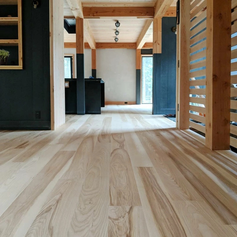 Bild på en minimalistisk hall, med ljust trägolv