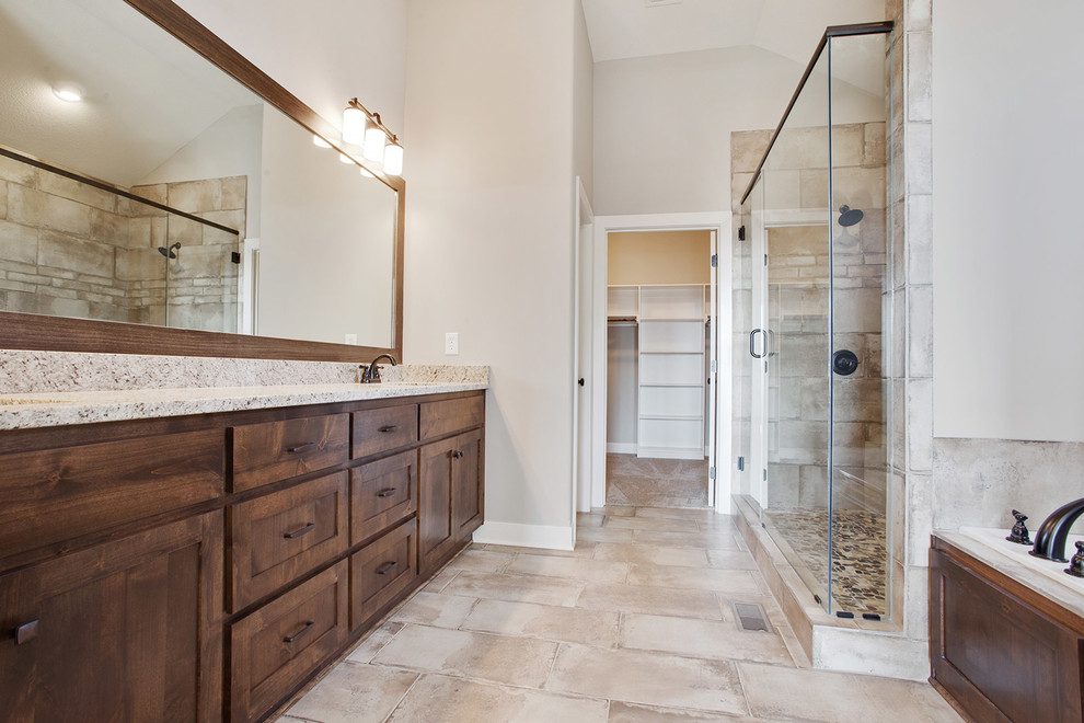 Country master bathroom in Kansas City with shaker cabinets, brown cabinets, a drop-in tub, an open shower, beige tile, ceramic tile, grey walls, ceramic floors, an undermount sink, granite benchtops, beige floor, a hinged shower door and beige benchtops.