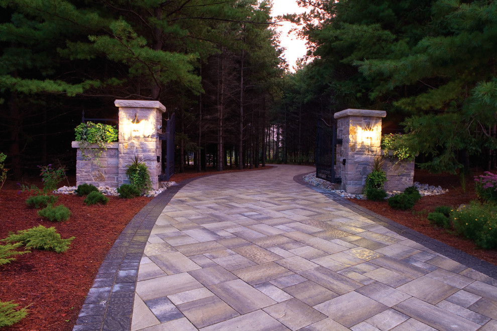 Design ideas for a large traditional front yard partial sun driveway in Toronto with brick pavers.