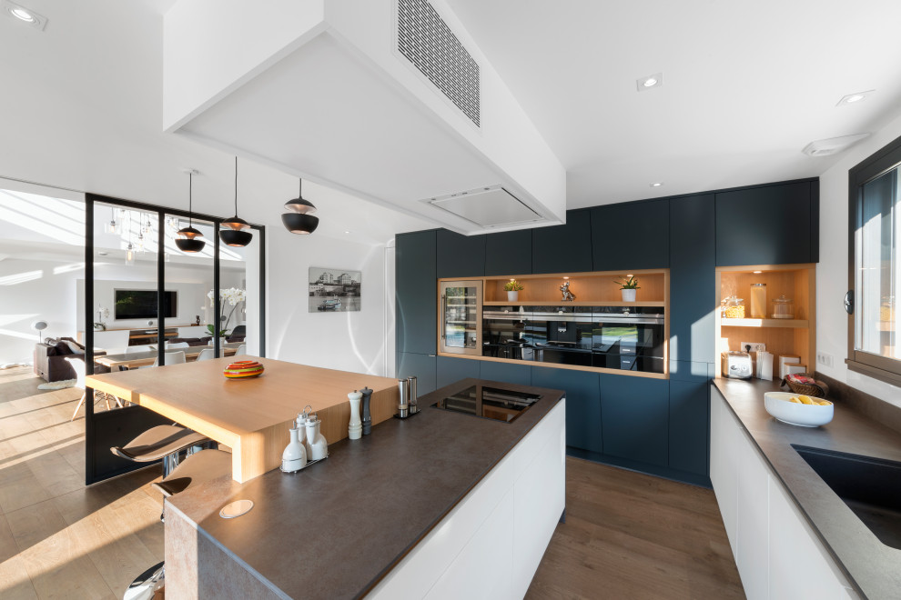 This is an example of a large contemporary l-shaped eat-in kitchen in Nantes with black cabinets and with island.