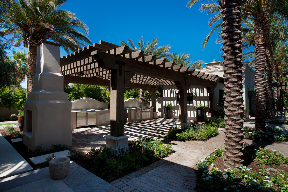 Design ideas for an expansive backyard patio in Phoenix with natural stone pavers and a roof extension.
