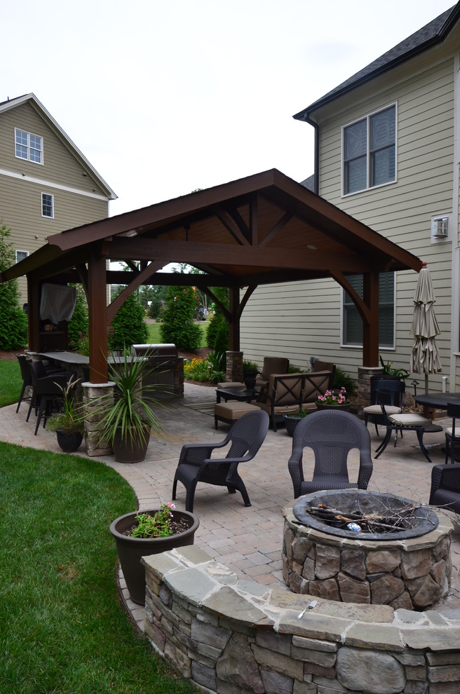 Mid-sized traditional backyard patio in Raleigh with an outdoor kitchen, concrete pavers and a gazebo/cabana.