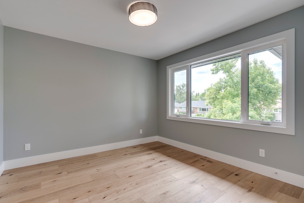 Bedroom - mid-sized transitional guest light wood floor and brown floor bedroom idea in Calgary with gray walls