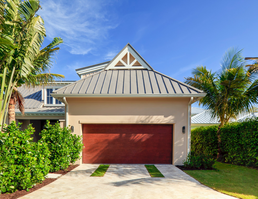 This is an example of a mid-sized tropical attached two-car garage in Miami.