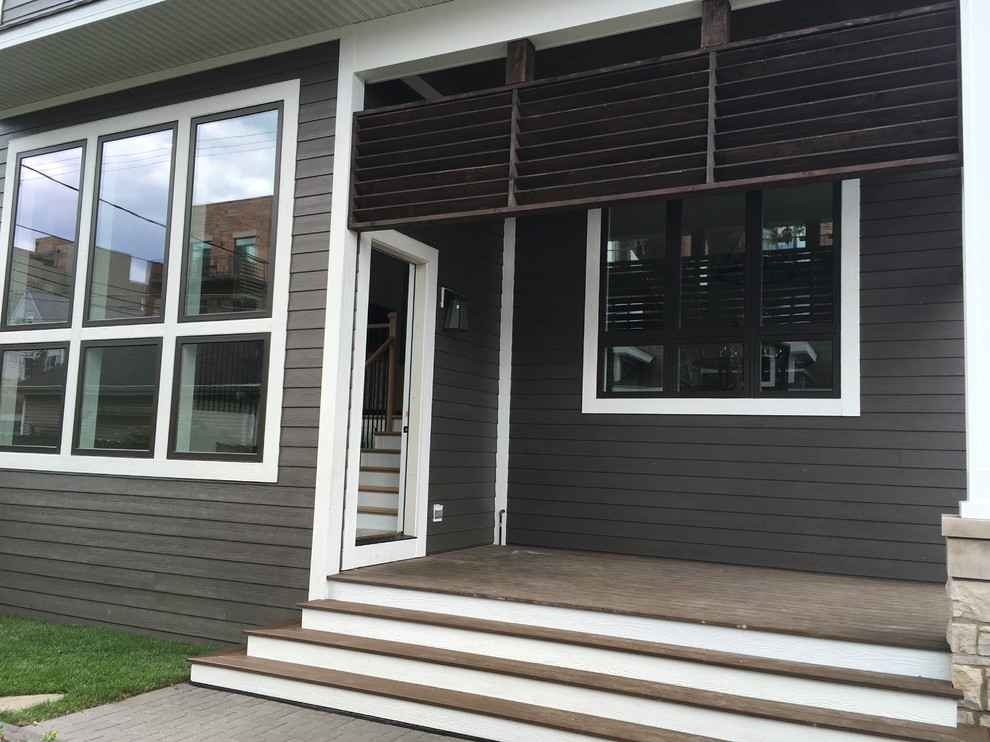 Example of a large transitional backyard home design design in Chicago with a roof extension