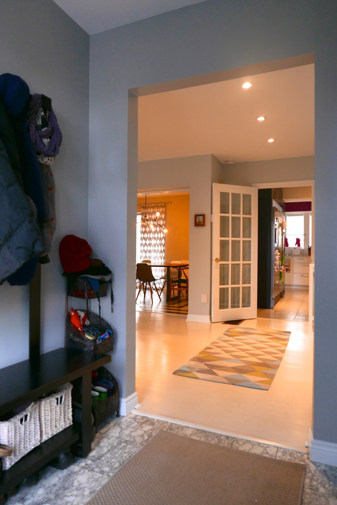 Example of a mid-sized eclectic ceramic tile mudroom design in Toronto with gray walls and a white front door