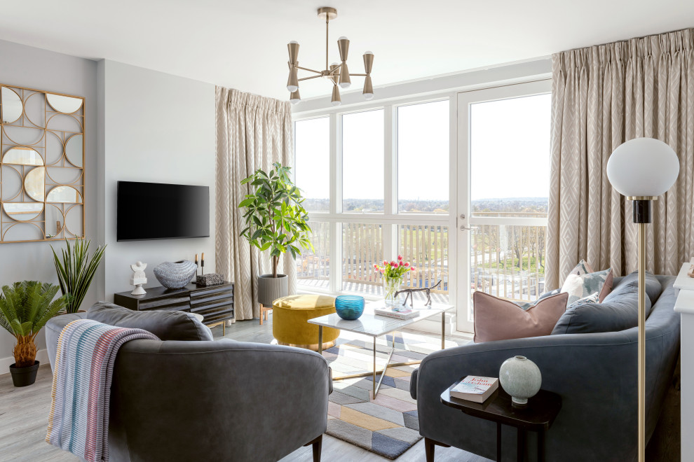 Foto di un soggiorno minimal di medie dimensioni e aperto con sala formale, pareti grigie e TV a parete