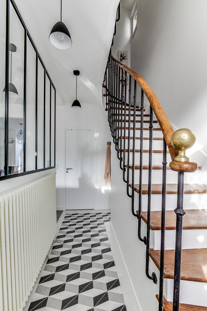 Inspiration for a scandinavian painted wood curved staircase in Paris with wood risers and mixed railing.