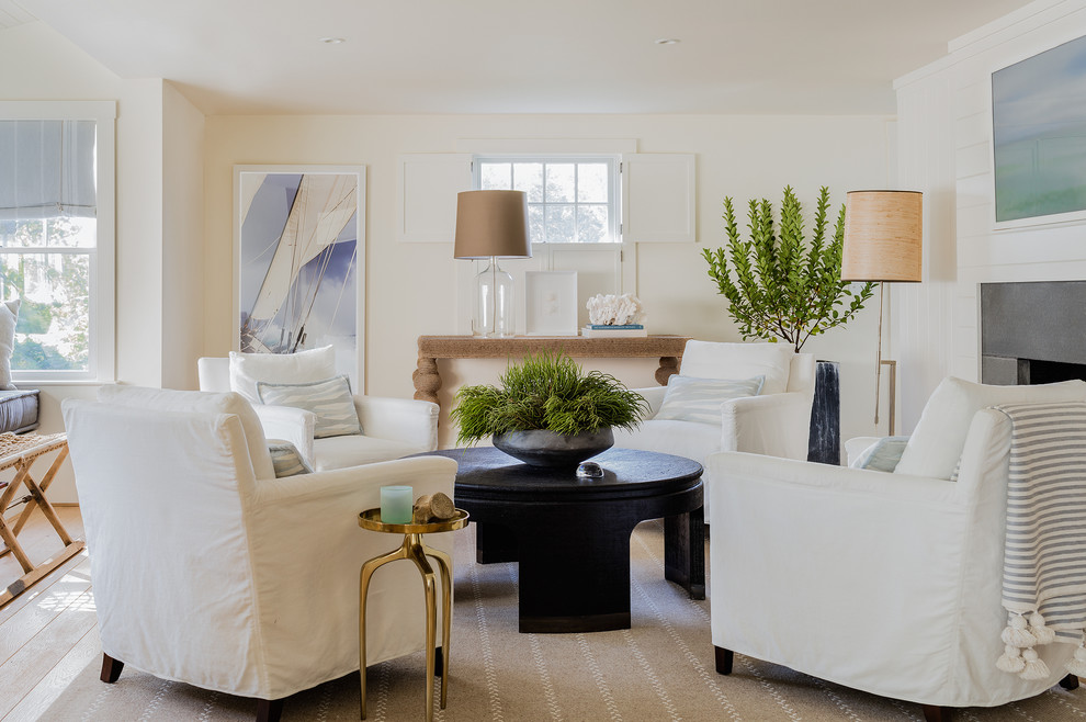 Design ideas for a transitional open concept living room in Boston with white walls, light hardwood floors, a standard fireplace, a stone fireplace surround and a concealed tv.