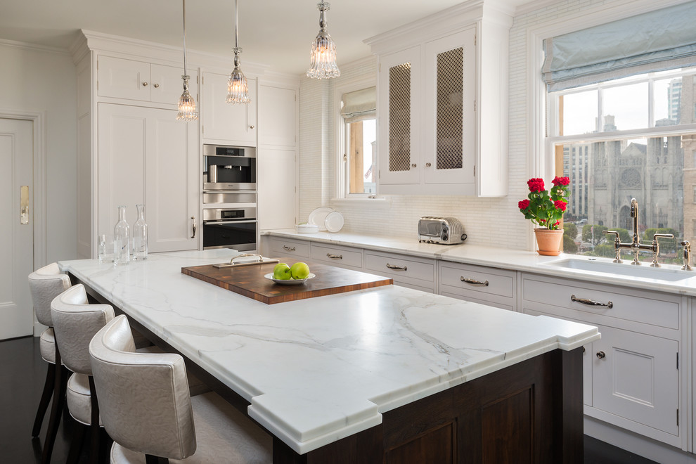 Inspiration for a transitional kitchen in San Francisco with an undermount sink, recessed-panel cabinets, white cabinets, marble benchtops and white splashback.