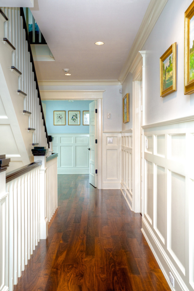 This is an example of a mid-sized beach style hallway in New York with grey walls, dark hardwood floors and brown floor.