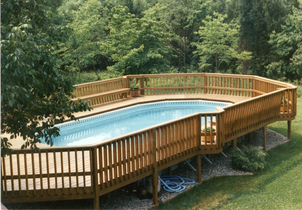 This is an example of a large traditional backyard custom-shaped aboveground pool in Newark with gravel.