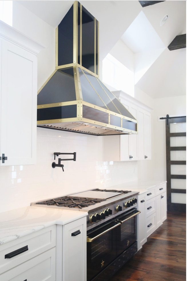 Large transitional l-shaped dark wood floor open concept kitchen photo with shaker cabinets, white cabinets, wood countertops, white backsplash, ceramic backsplash, an island, a double-bowl sink and stainless steel appliances