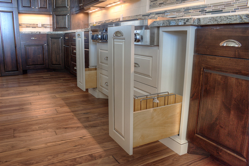 Traditional kitchen in Salt Lake City with dark wood cabinets, multi-coloured splashback, medium hardwood floors and with island.